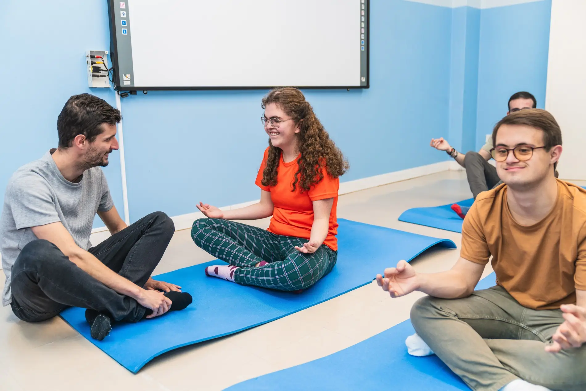 Support worker with group of NDIS participants in Yoga class