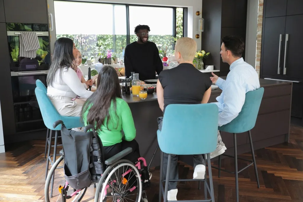 Group of NDIS participants in kitchen all laughing together