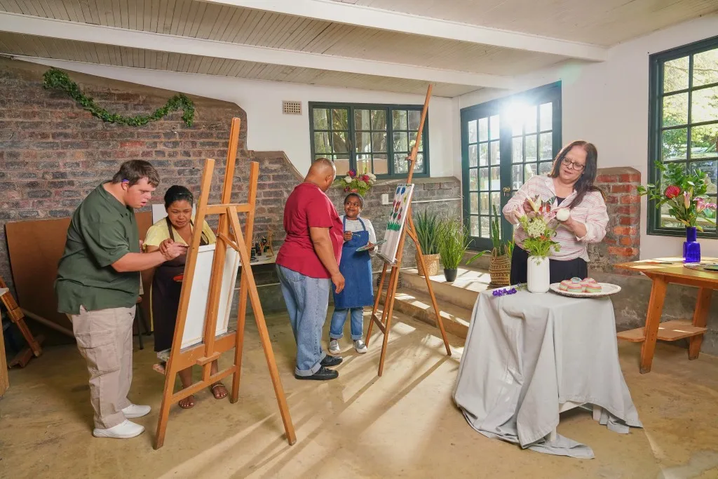 Group of disabled friends in art class with support worker