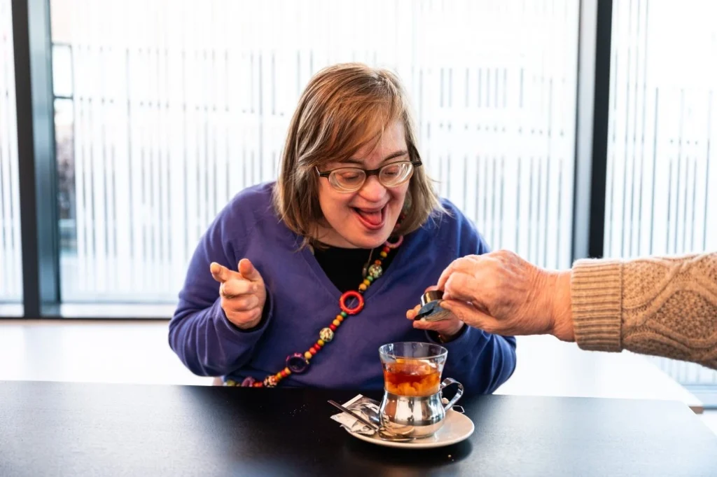 Happy disabled woman having a cup of tea at café